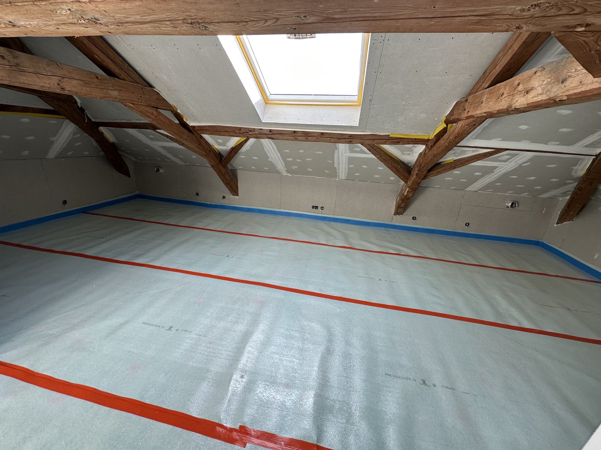 Pare-vapeur posé et jointoyé sous charpente avant fermeture sur un chantier KGK