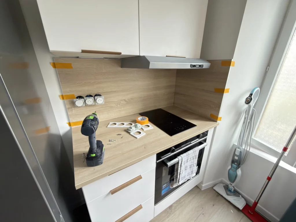 Plan de travail et crédence de cuisine avec ruban de masquage et outils en cours de chantier.