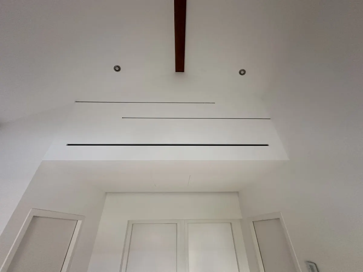 Plafond blanc avec découpes linéaires et spots